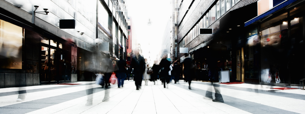 Heavily blurred wide shot of a generic high street filled with featureless shoppers