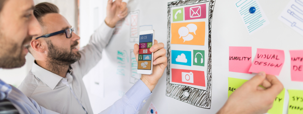 Men designing an app on a whiteboard 