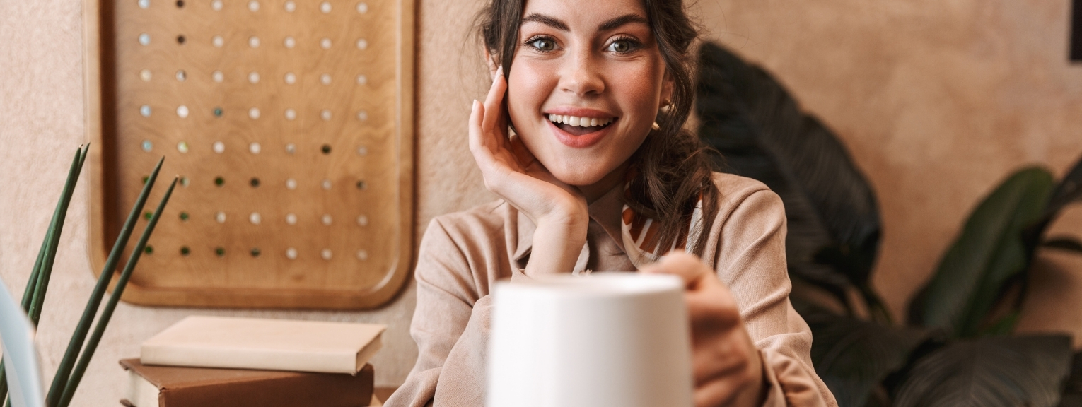 Lady in office holding up a mug