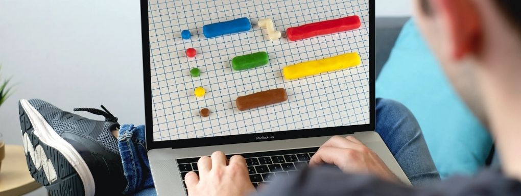 Man on laptop looking at plasticine gantt chart