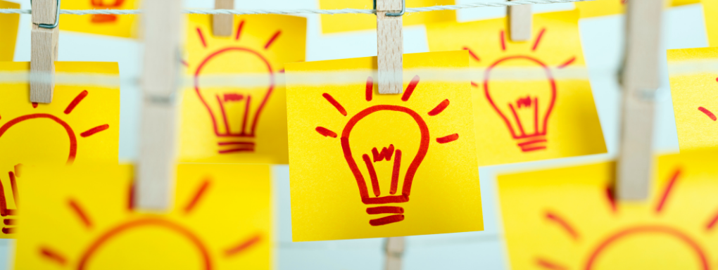 Yellow post-it notes with red lightbulb drawings pegged to a washing line